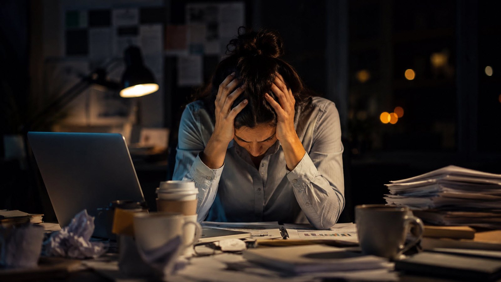 Persona agotada en su oficina mostrando síntomas de burnout laboral y estrés crónico